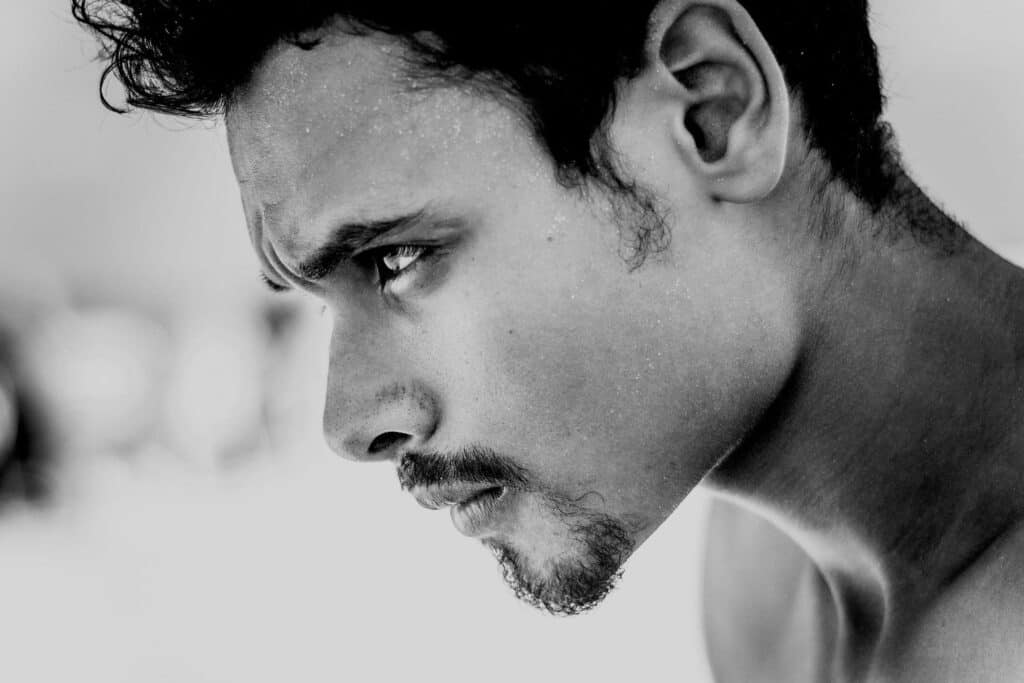 Homme pensif au regard concentré, représentant une prise de conscience intérieure face à la timidité.