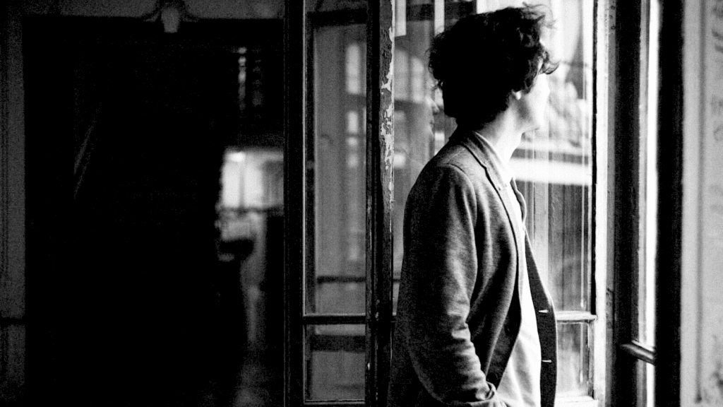 Homme introverti regarde par la fenêtre