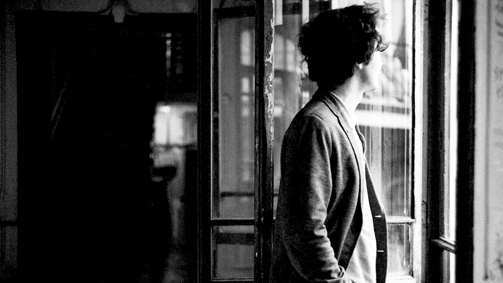 Homme introverti regarde par la fenêtre