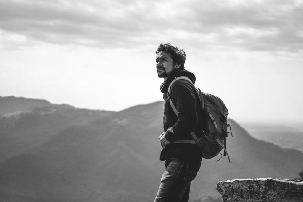 Homme debout face à un paysage ouvert, symbolisant le courage de sortir de sa zone de confort.