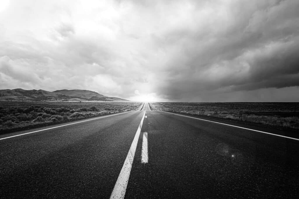 Route droite menant vers la lumière à l’horizon, symbole d’affirmation de soi et de transformation personnelle.