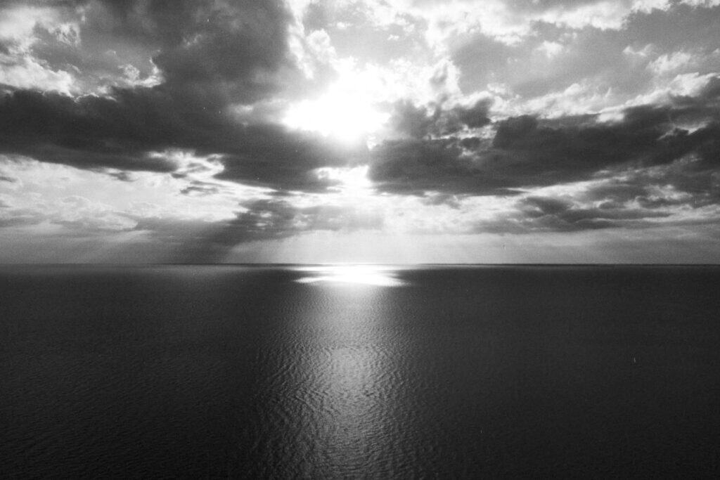 Horizon lumineux au-dessus de la mer calme, évoquant le détachement émotionnel et la clarté intérieure.